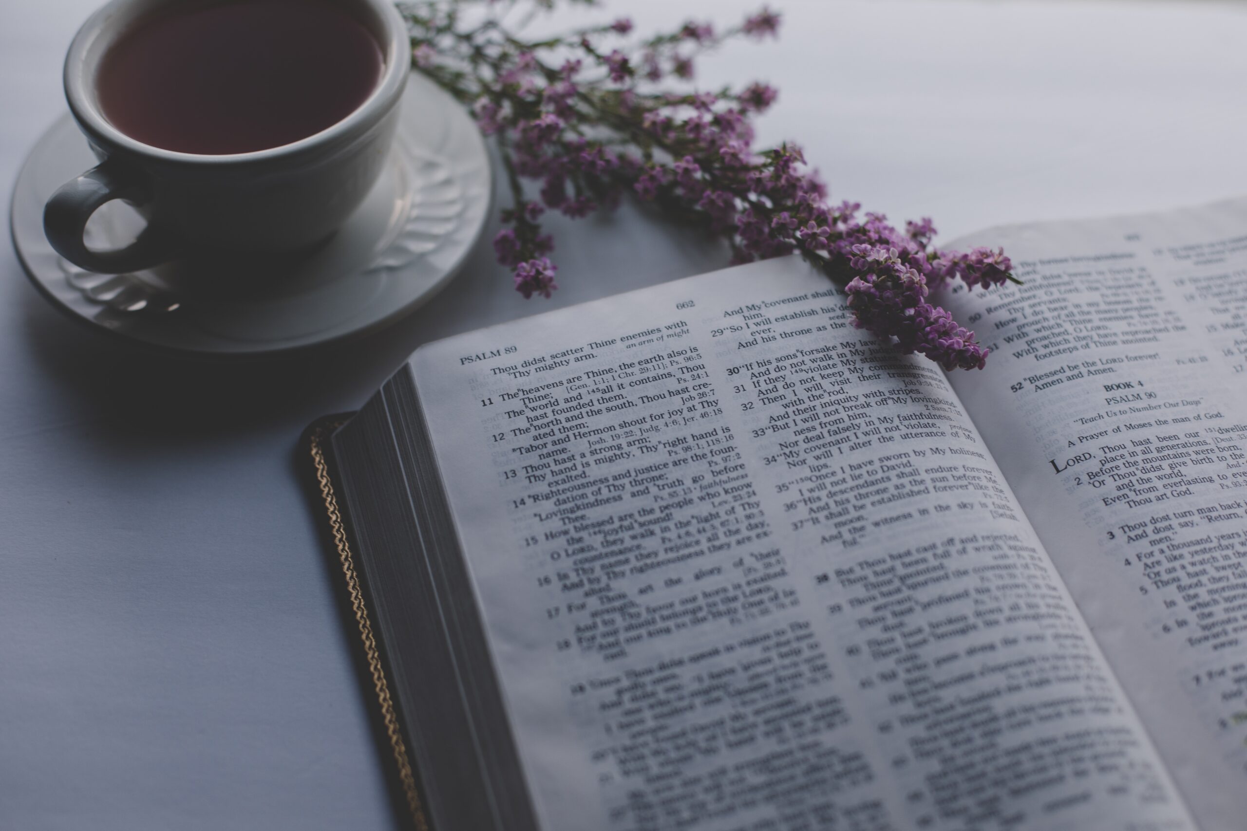 open bible on a table with a cup of coffee
